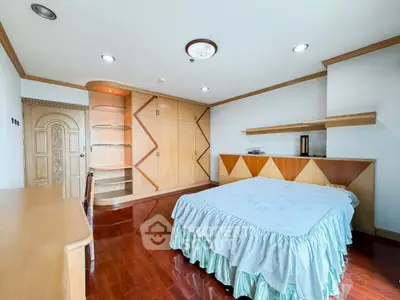 Spacious bedroom with elegant wooden furnishings and ample storage space
