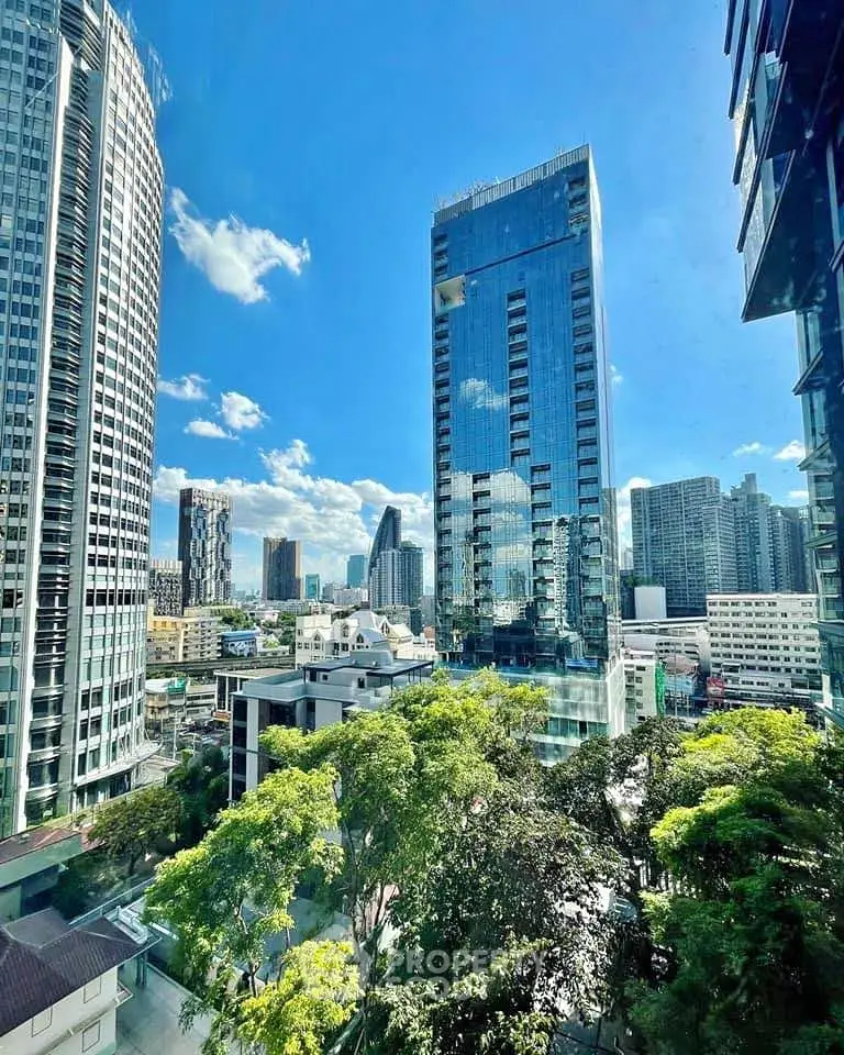 Stunning cityscape view from a high-rise building with lush greenery and modern architecture.