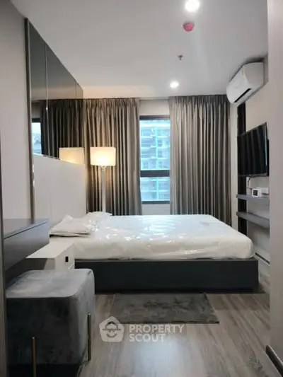 Modern bedroom with sleek design, large window, and stylish furnishings.