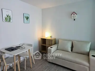 Cozy living room with modern decor, featuring a comfortable sofa and stylish dining area.