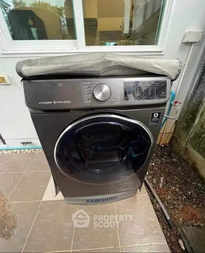 Modern Samsung washing machine on tiled outdoor patio area.