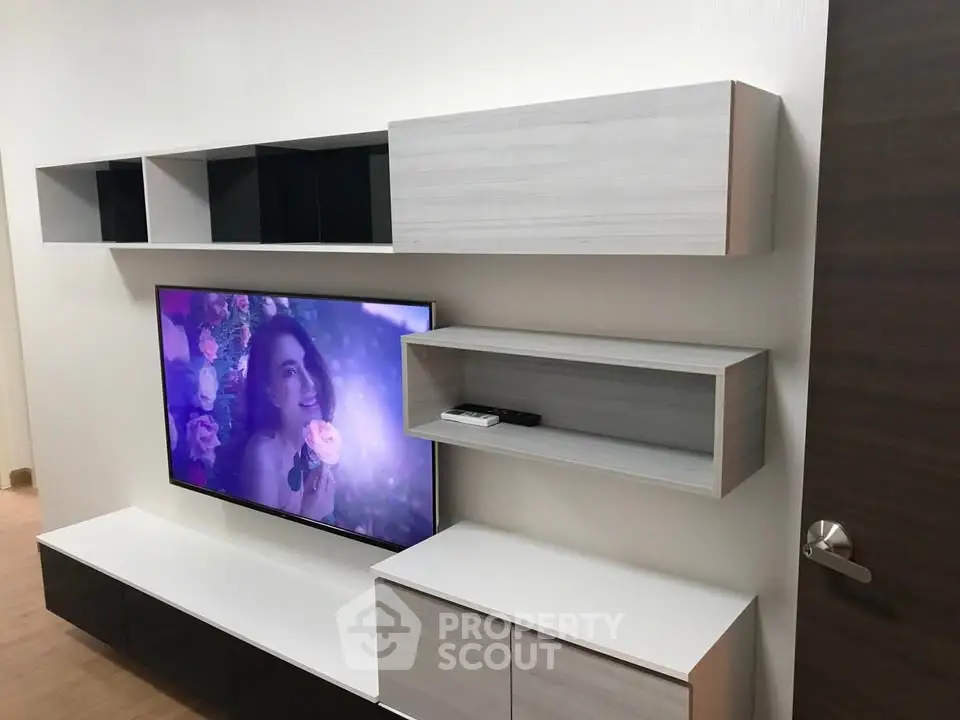 Modern living room with sleek wall-mounted TV and stylish shelving units.