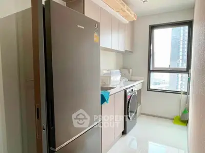 Modern kitchen with sleek appliances and city view, featuring a fridge and washing machine.