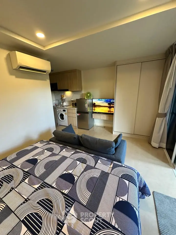 Modern studio apartment with stylish decor, featuring a compact kitchen and cozy living area.