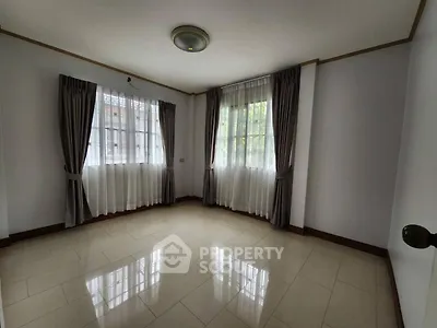 Spacious empty room with large windows and elegant curtains