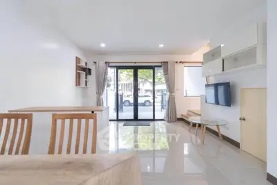 Spacious modern living room with large windows and stylish furniture, perfect for relaxation and entertainment.