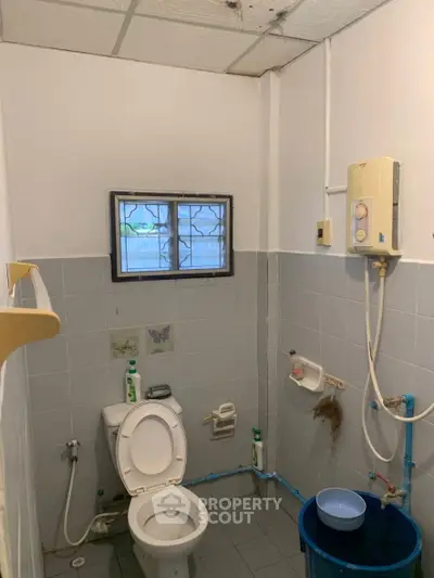 Compact bathroom with essential fixtures and natural light from a small window.