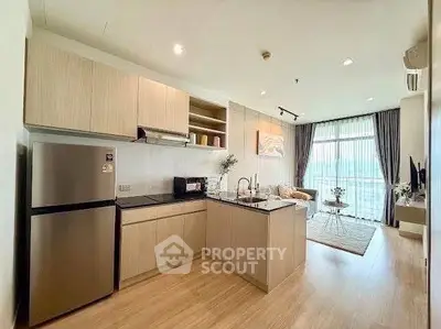 Modern open-layout kitchen and living room with natural light and stylish decor.