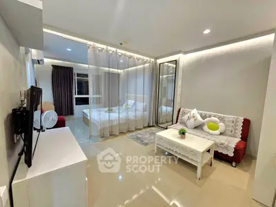 Modern open-plan living room with cozy seating and elegant bedroom divider