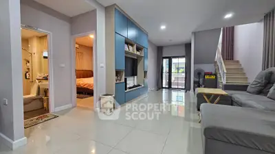 Spacious modern living room with sleek design and open layout, featuring a cozy bedroom view.