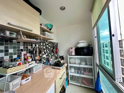 Compact kitchen with modern appliances and large window offering natural light