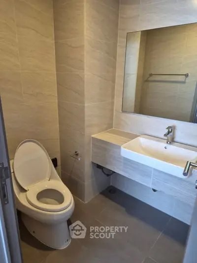 Modern bathroom with sleek design and wall-mounted sink in a contemporary apartment.