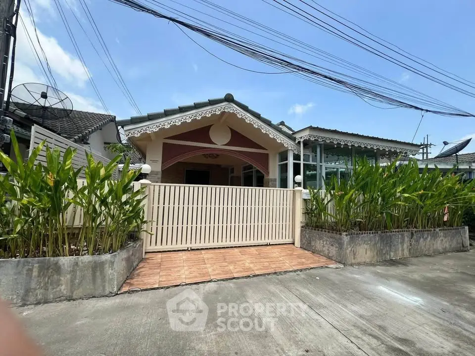 Charming single-story house with gated entrance and lush greenery