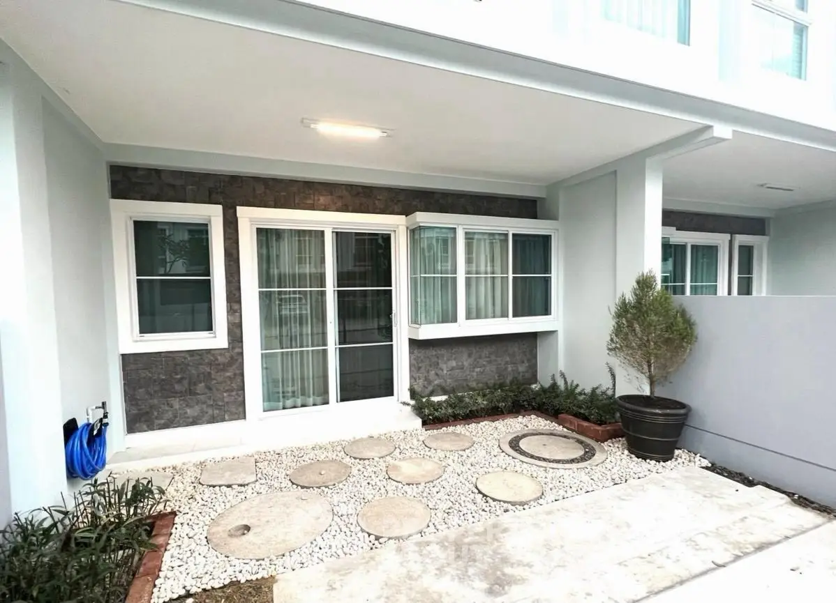 Modern exterior with stylish stone accents and landscaped garden entryway