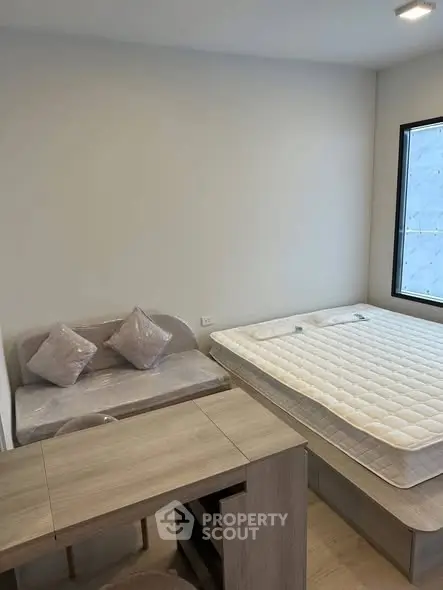 Cozy bedroom with modern furniture and natural light, perfect for a comfortable living experience.