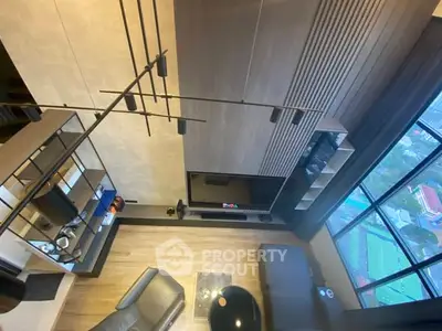 Modern living room with high ceiling and large window offering stunning city view.