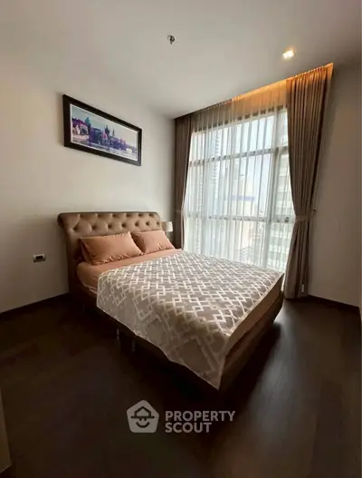 Cozy bedroom with elegant decor and large window offering city views