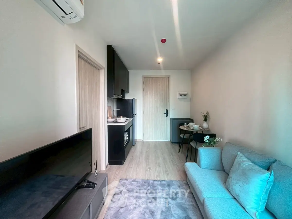 Modern living room with cozy sofa and compact kitchen in open layout