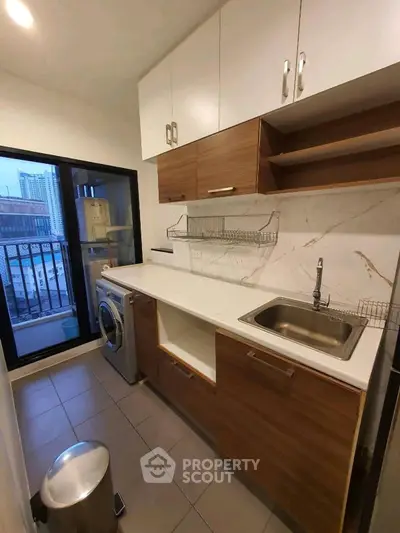 Modern kitchen with sleek cabinets and balcony view