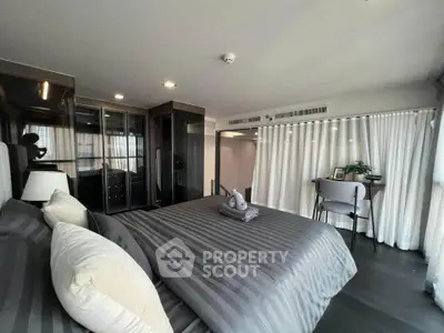 Luxurious bedroom with modern decor and ample natural light, featuring a cozy bed and stylish workspace.