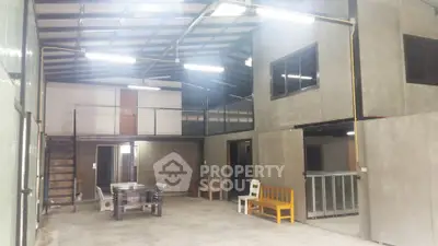 Spacious industrial-style interior with high ceilings and modern design.