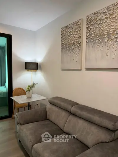 Modern living room with stylish gray sofa and elegant wall art in a cozy apartment setting.