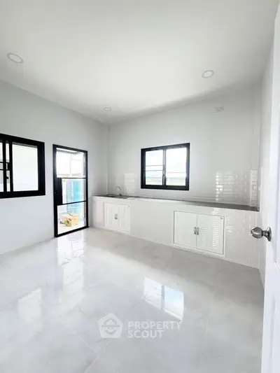 Spacious modern kitchen with sleek countertops and ample natural light