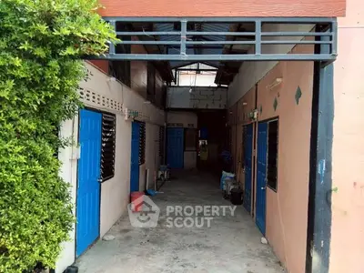 Charming alleyway entrance with vibrant blue doors and lush greenery