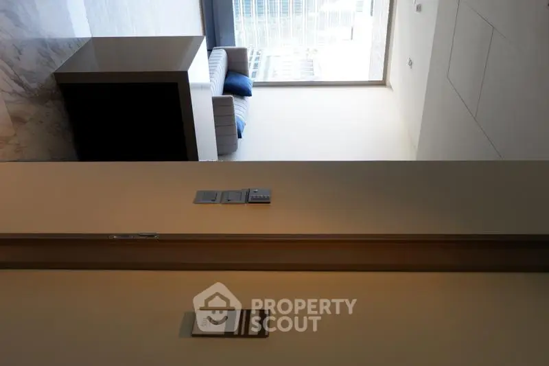 Modern apartment interior with marble flooring and city view from large window.