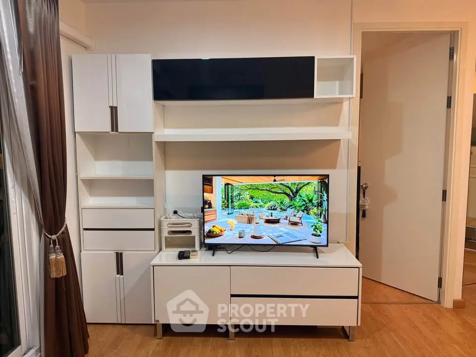 Modern living room with sleek white entertainment unit and TV, showcasing stylish interior design.
