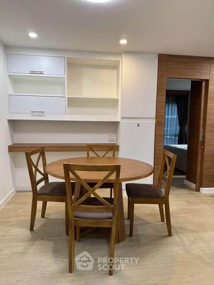 Modern dining area with wooden table and chairs in a stylish apartment interior.