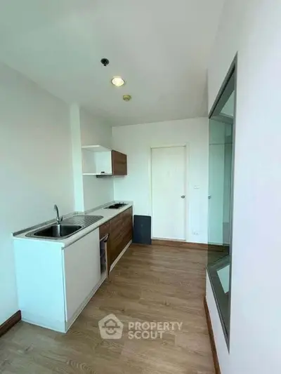 Modern minimalist kitchen with sleek cabinetry and wooden flooring