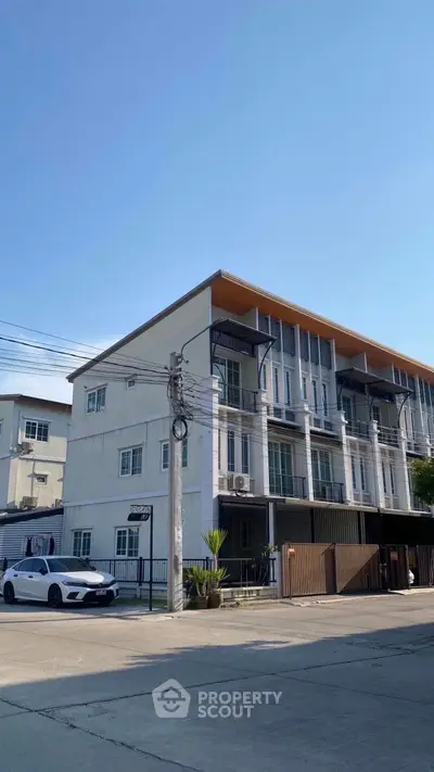 Modern townhouse exterior with sleek design and large windows in urban setting.