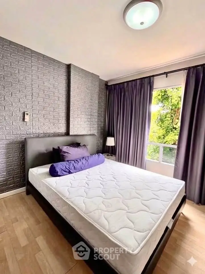 Modern bedroom with stylish decor and large window offering natural light and garden view.