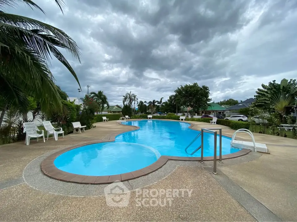 Stunning outdoor pool area with lush greenery and inviting lounge chairs.