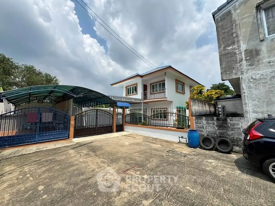 Charming two-story house with gated driveway and carport, perfect for family living in a serene neighborhood.