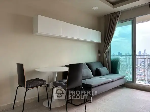 Modern living room with city view, featuring sleek furniture and large windows for natural light.