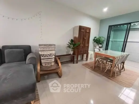 Modern living room with stylish furniture and dining area, featuring sleek tile flooring and natural light.