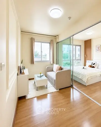 Bright and cozy living room with sliding glass doors leading to a stylish bedroom, perfect for modern living.