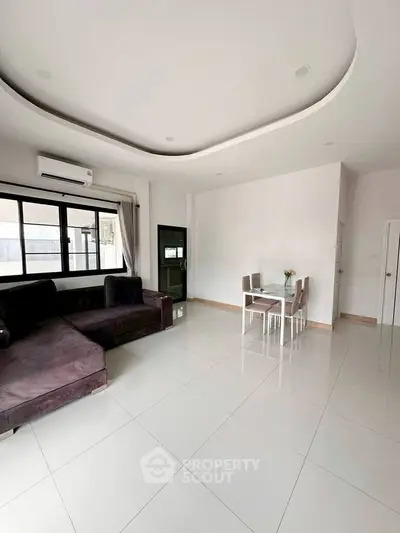 Spacious modern living room with elegant dining area and sleek furniture.