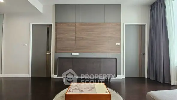 Modern living room with stylish wood paneling and dark flooring
