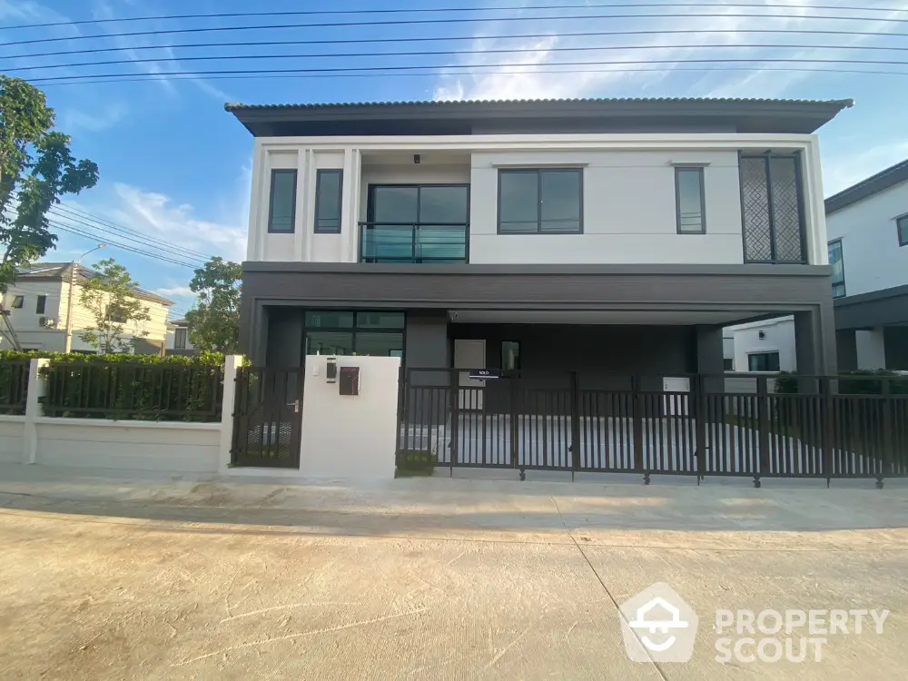 Modern two-story house with sleek design and spacious driveway in a serene neighborhood.