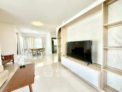 Spacious modern living room with TV and dining area, bright and airy design.