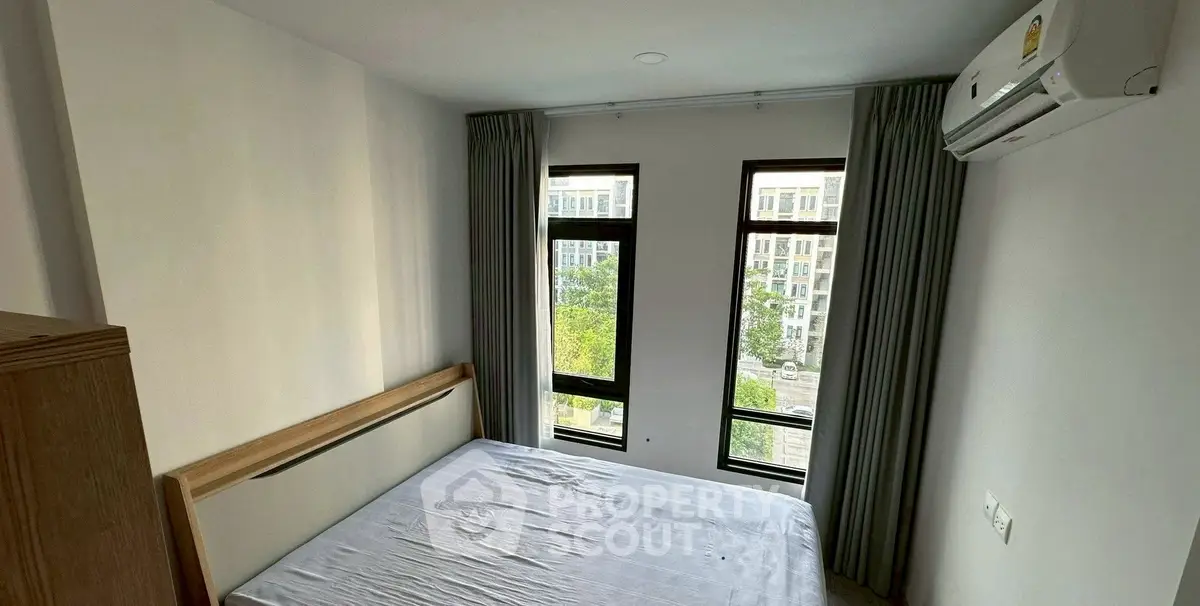 Cozy bedroom with large windows and air conditioning unit