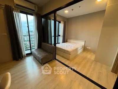 Modern condo with glass partition, cozy bedroom, and city view balcony.