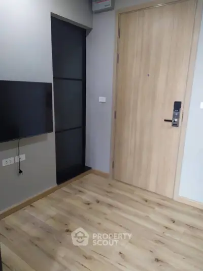 Modern apartment entrance with sleek wooden door and laminate flooring
