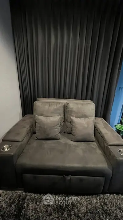 Luxurious home theater seating with plush cushions and cup holders, perfect for a cozy movie night.