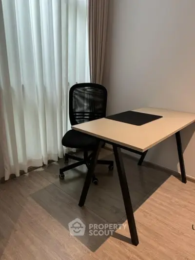 Modern study room with sleek desk and ergonomic chair by a window.