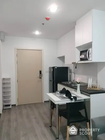 Modern kitchen with sleek cabinetry and dining area in stylish apartment