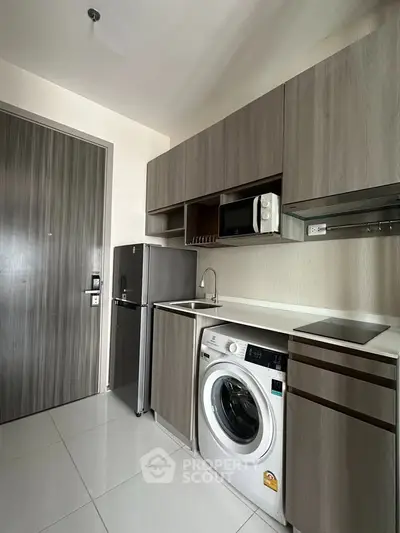 Modern kitchen with sleek cabinetry, washing machine, and compact appliances in a stylish apartment.